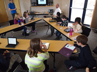 Technology in Education - Teacher using technology like iPad and tablets in teaching his students inside the classroom. 