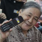 Lola Dominga shows the Cloudfone Lite Senior Flip she received during Cloudfone's CSR Give-Back Project.